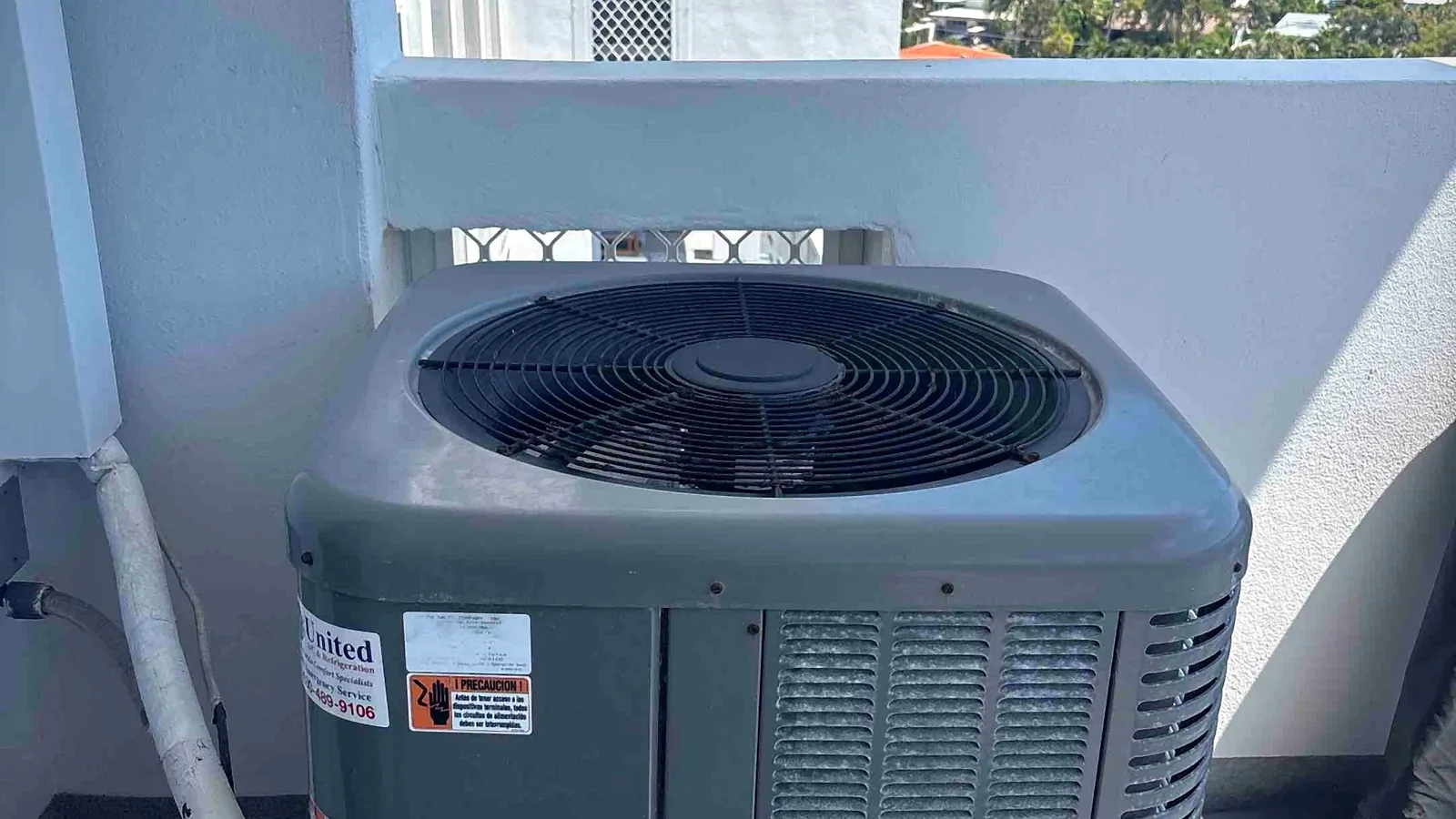Balcony-mounted air conditioning condenser at a high-rise overlooking the ocean