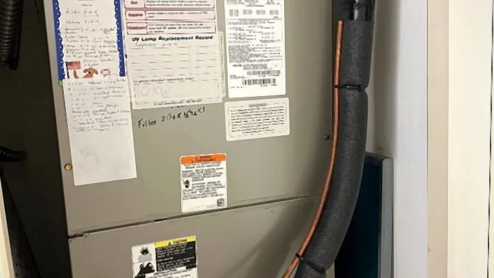 Air handler with maintenance log and UV lamp service reminder cards inside an indoor closet