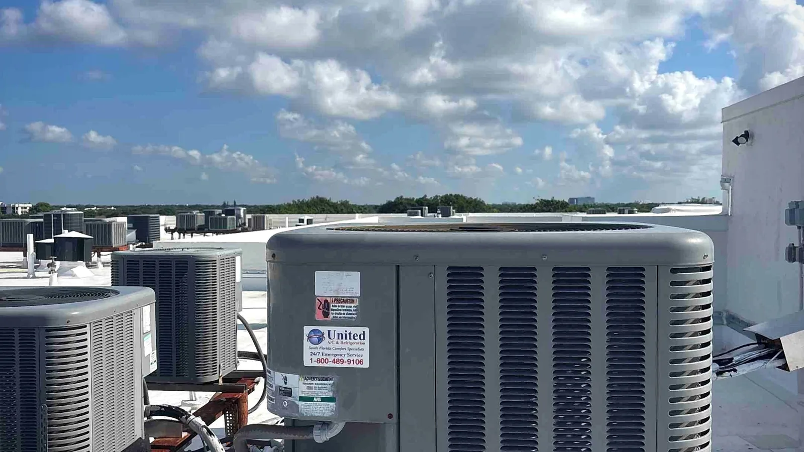 Rooftop condensing unit with electrical disconnect under towering clouds