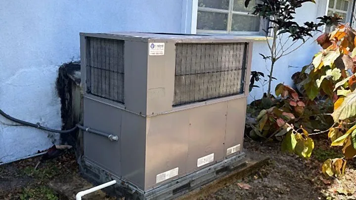 Ground-mounted packaged air conditioning unit on a slab with condensate drain line