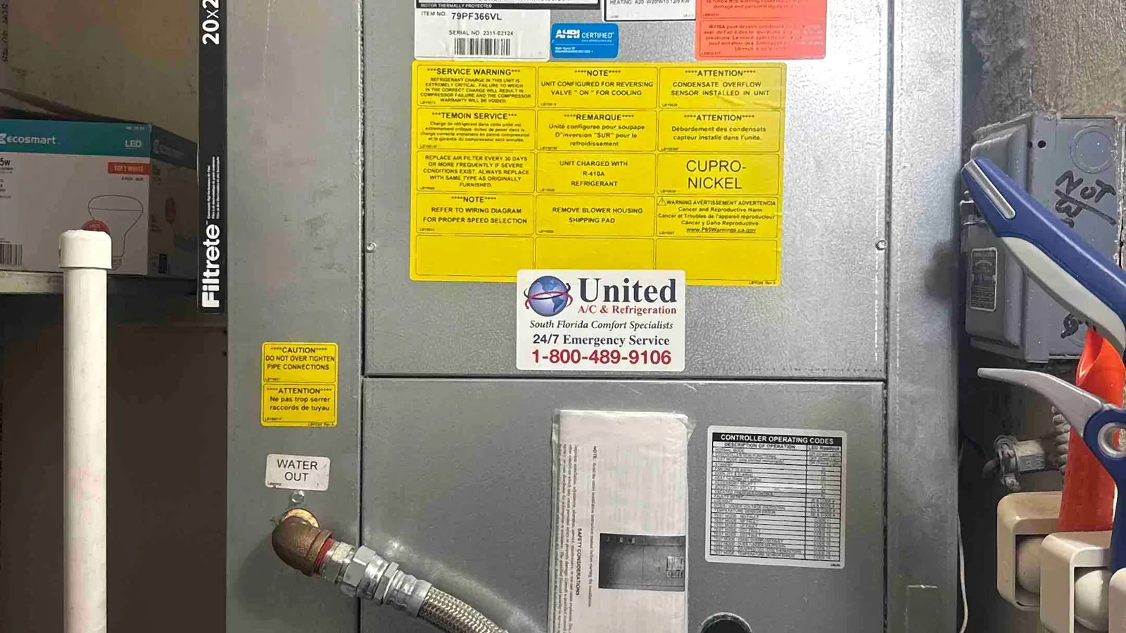 Water source heat pump in a condo closet with braided supply hoses and condensate drain piping