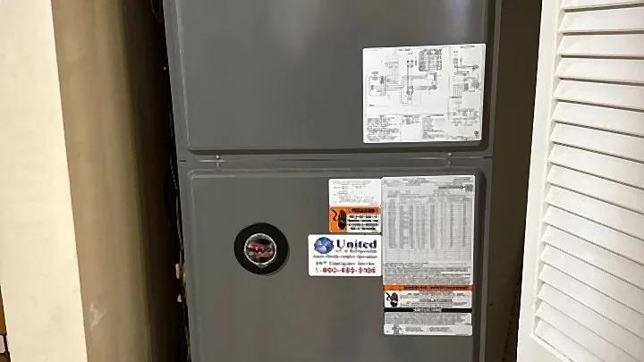 Indoor vertical air handler in a closet with service labeling and PVC condensate piping