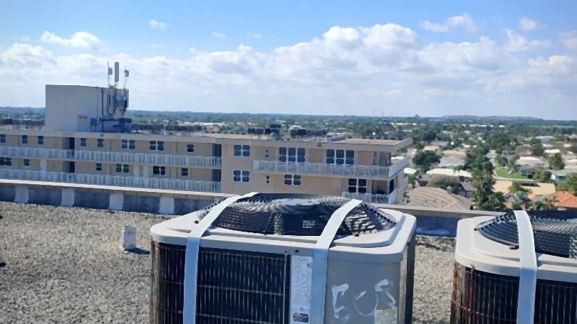 Aging rooftop condensers with rusted bases awaiting service or replacement