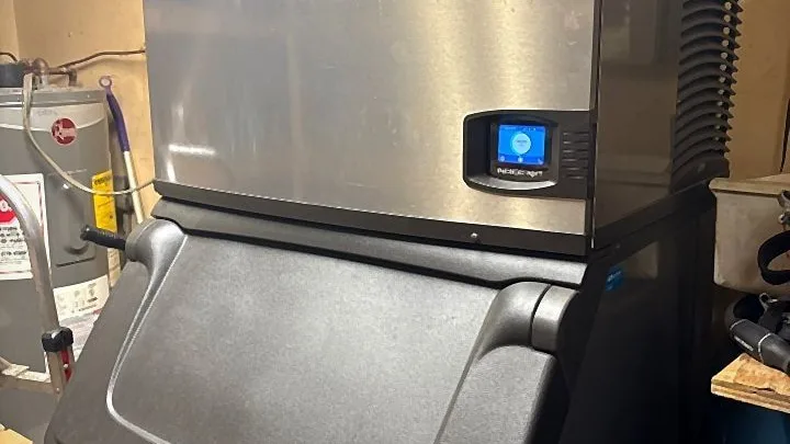 Commercial ice machine and storage bin serviced by a refrigeration technician
