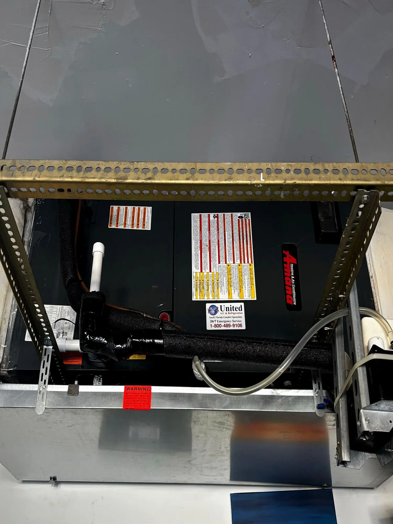 Suspended Amana horizontal air handler on strut hangers with insulated line set and condensate drain