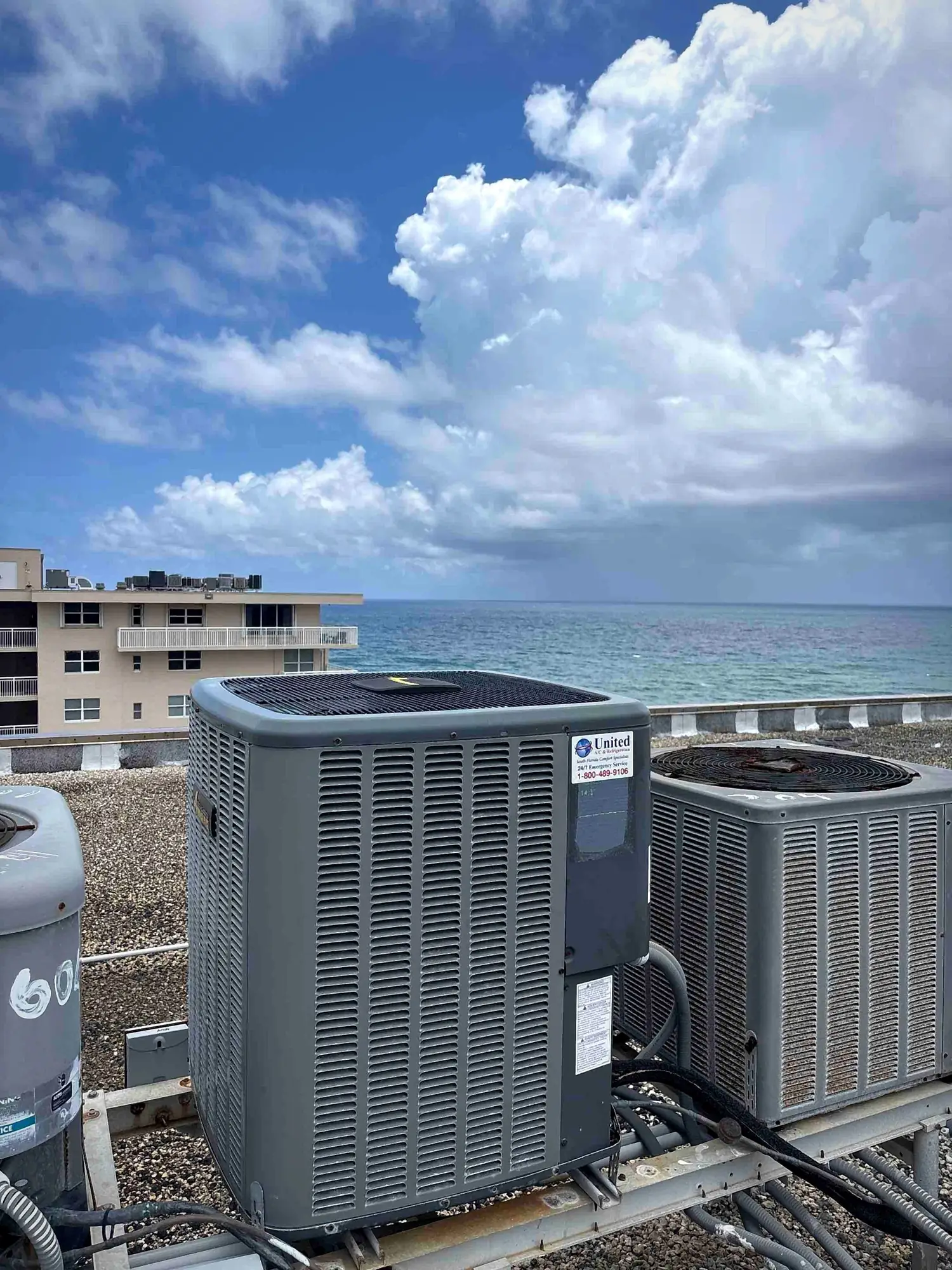 Oceanfront rooftop air conditioning condensers overlooking the water at a condo building