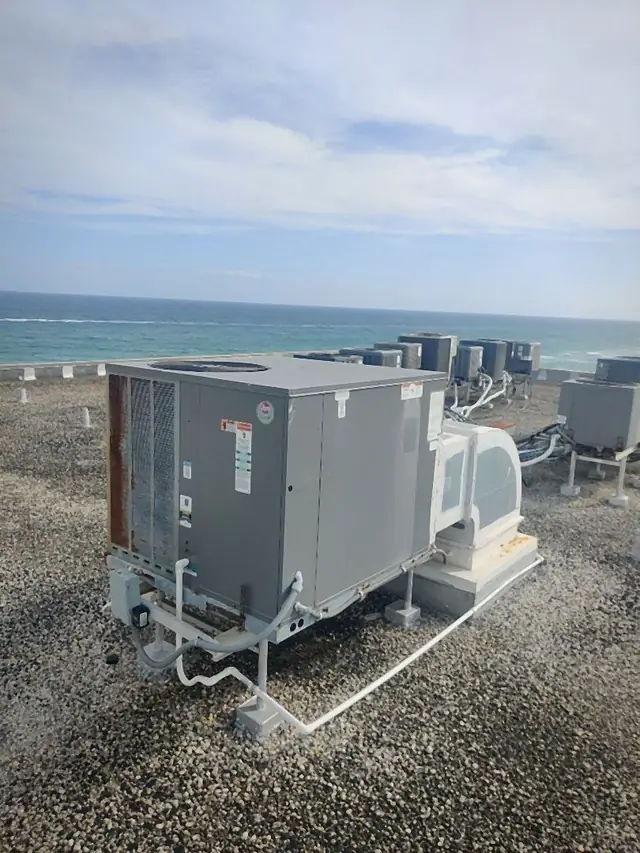 Packaged rooftop air conditioning unit on an oceanfront roof with condensate and refrigerant lines