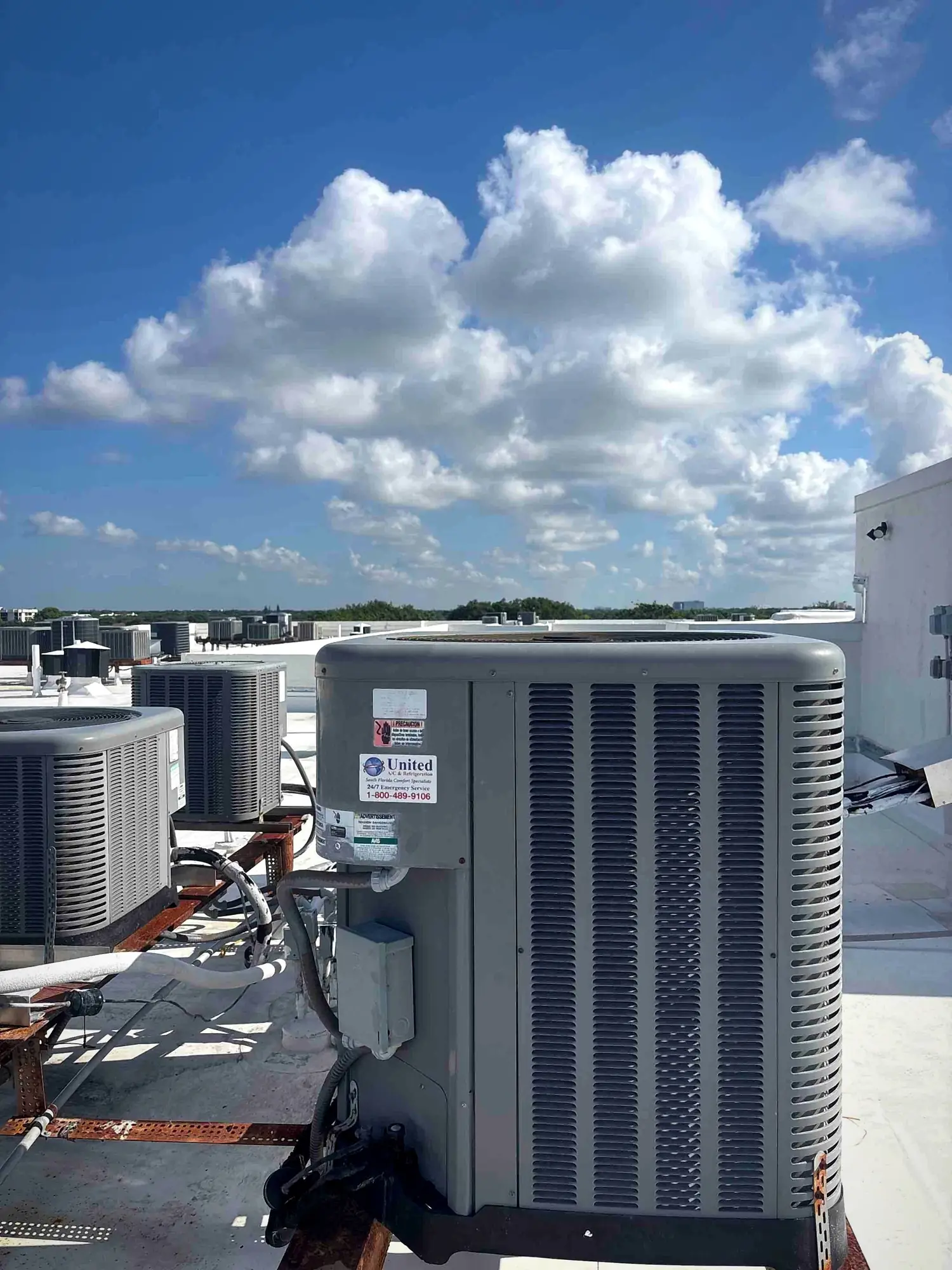 Rooftop condensing unit with electrical disconnect under towering clouds