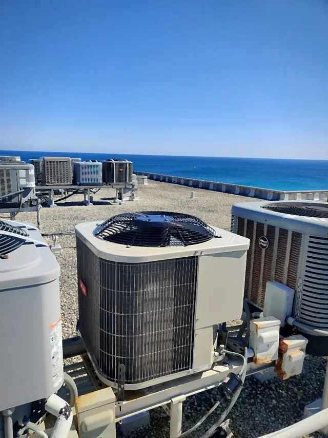 Rooftop air conditioning units on a gravel roof above the open ocean