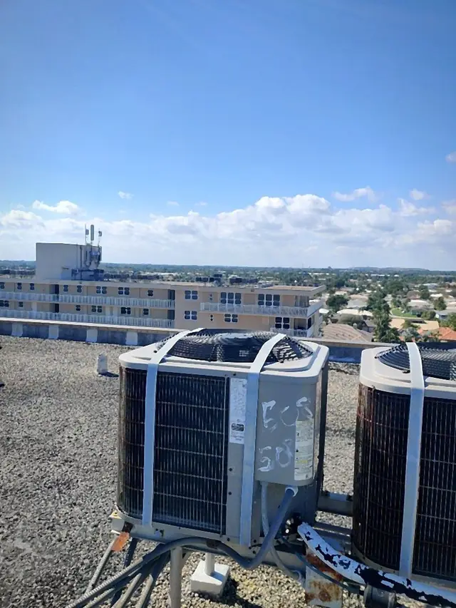 Aging rooftop condensers with rusted bases awaiting service or replacement